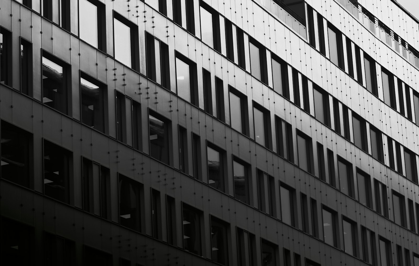 Modern kontorsbyggnad i glas och sten i svenskt företagskvarter